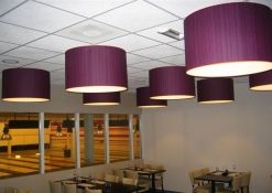 paarse hanglampen gemonteerd aan systeem plafond